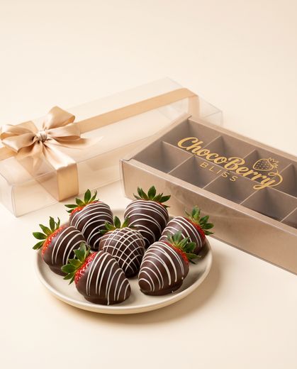 Chocolate drizzle being piped over a strawberry