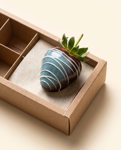 Close-up of a blue cocoa-butter painted chocolate strawberry
