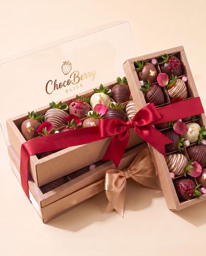 Three boxes — two stacked and one beside — tied with a red ribbon, thirty-six berries